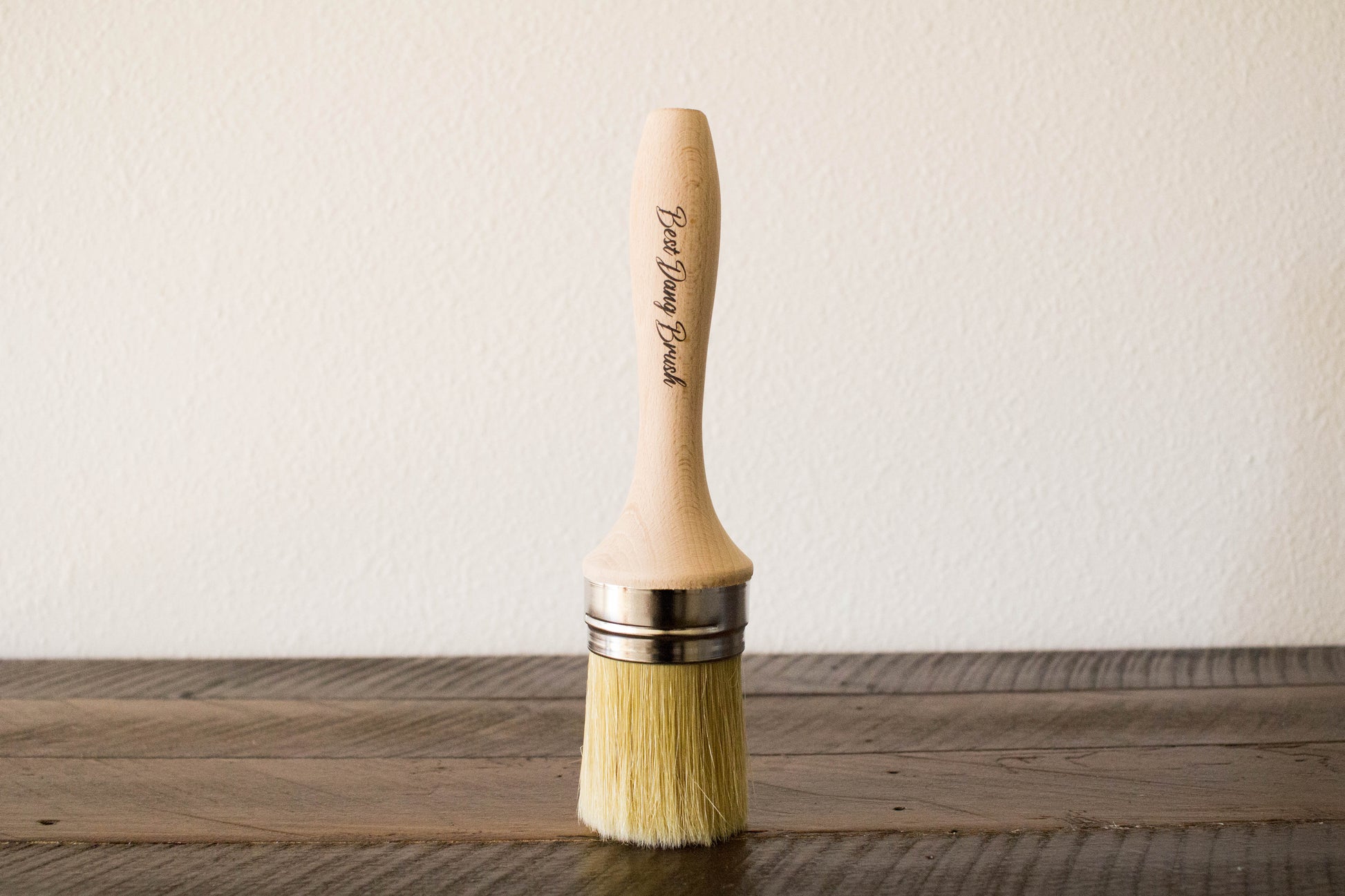 Dixie Belle Best Dang Brush – round natural bristle brush with hardwood handle standing upright on a wood surface