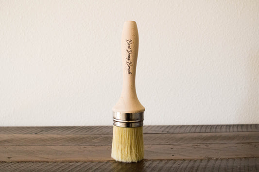 Dixie Belle Best Dang Brush – round natural bristle brush with hardwood handle standing upright on a wood surface