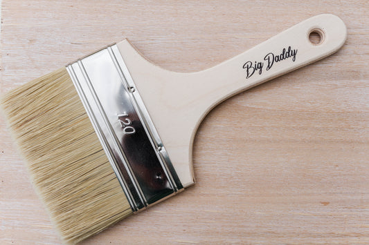 Dixie Belle Big Daddy Brush – wide flat natural bristle brush with hardwood handle on a wood surface