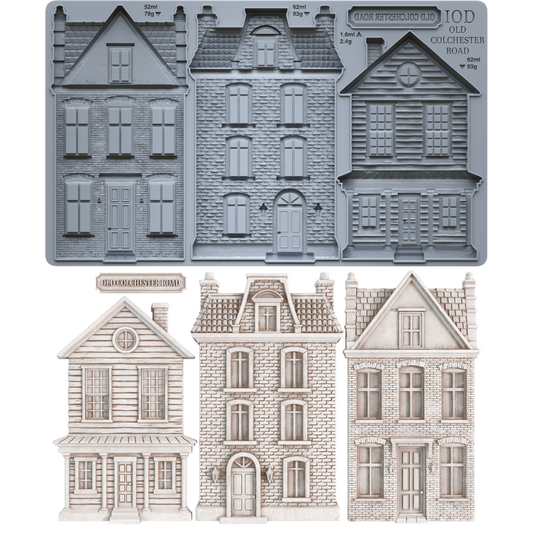 IOD Old Colchester Road Mould — grey silicone mould with three Victorian townhouse cavities and street sign plaque, shown with finished white castings of clapboard colonial, French brick townhouse, and Georgian row house