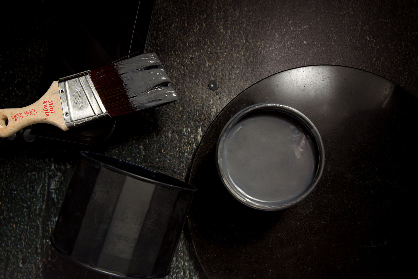 Dixie Belle Patina Paint Iron open jar showing dark charcoal metallic finish with brush